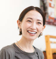 a japanese woman works at a clothing store. she is folding clothes.